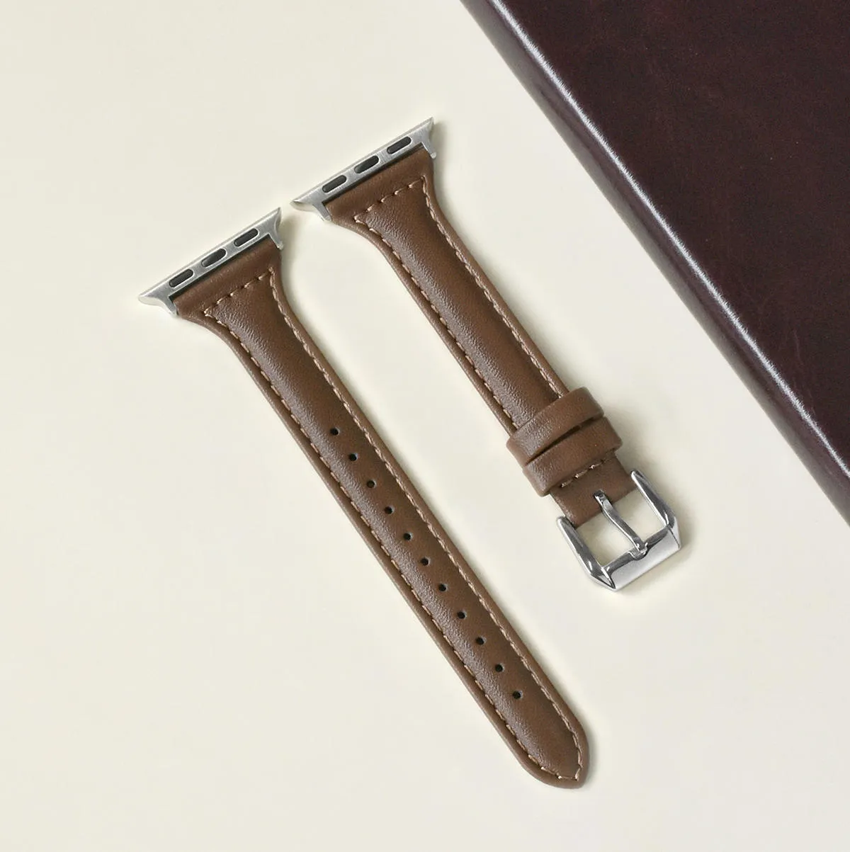 Women's retro slim leather strap for Apple Watch in cream apricot colour on a table