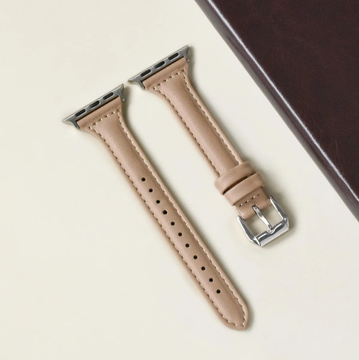 Women's retro slim leather strap for Apple Watch in cream apricot colour on a table