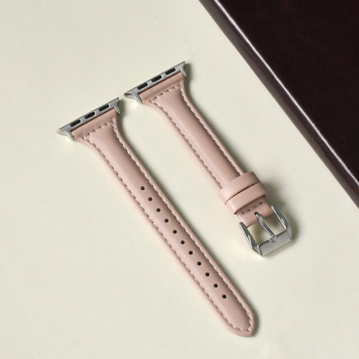 Women's retro slim leather strap for Apple Watch in cream apricot colour on a table