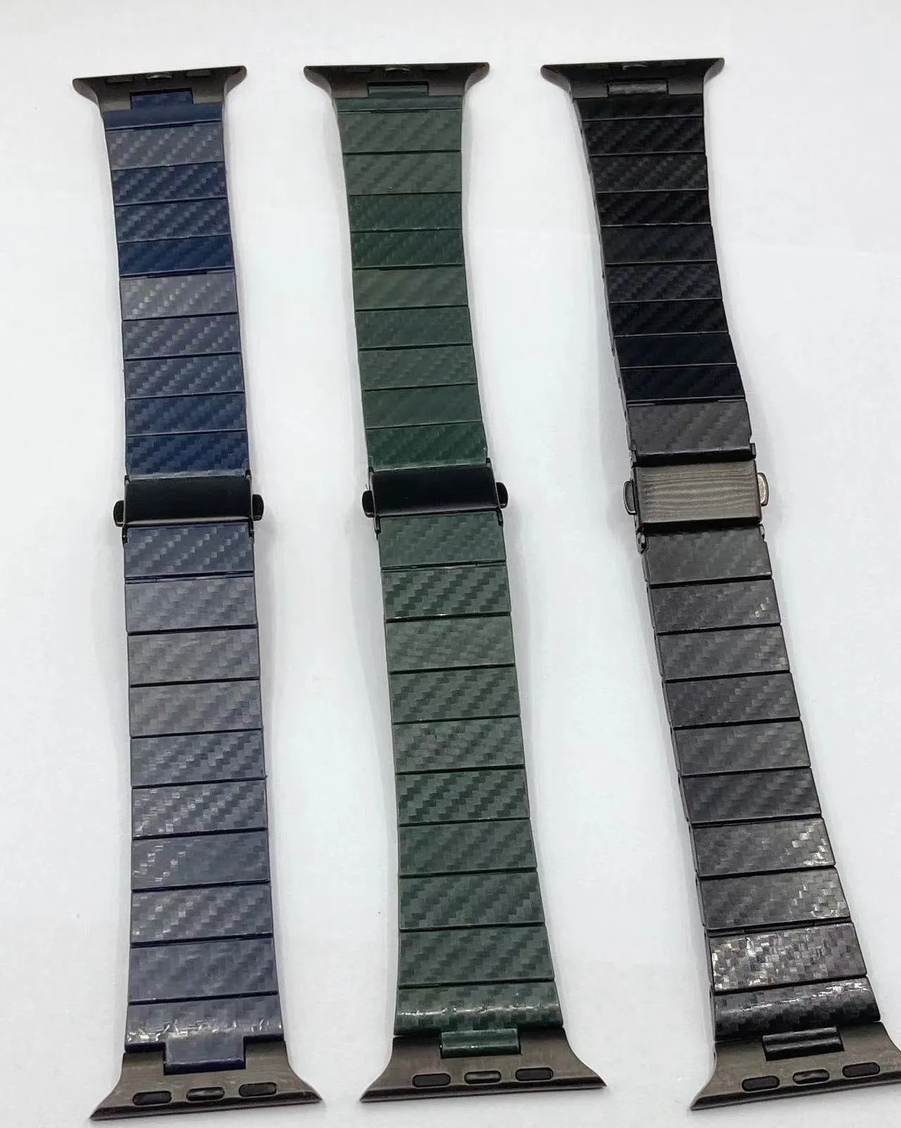 Black carbon fiber watch band for Apple Watch showing chain links and metal clasp on a white background
