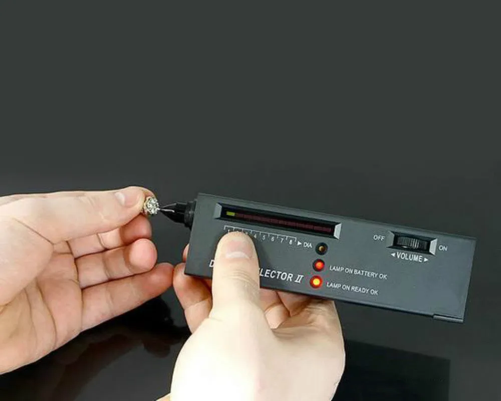Black handheld diamond thermal conductivity meter with metal probe on a white background.
