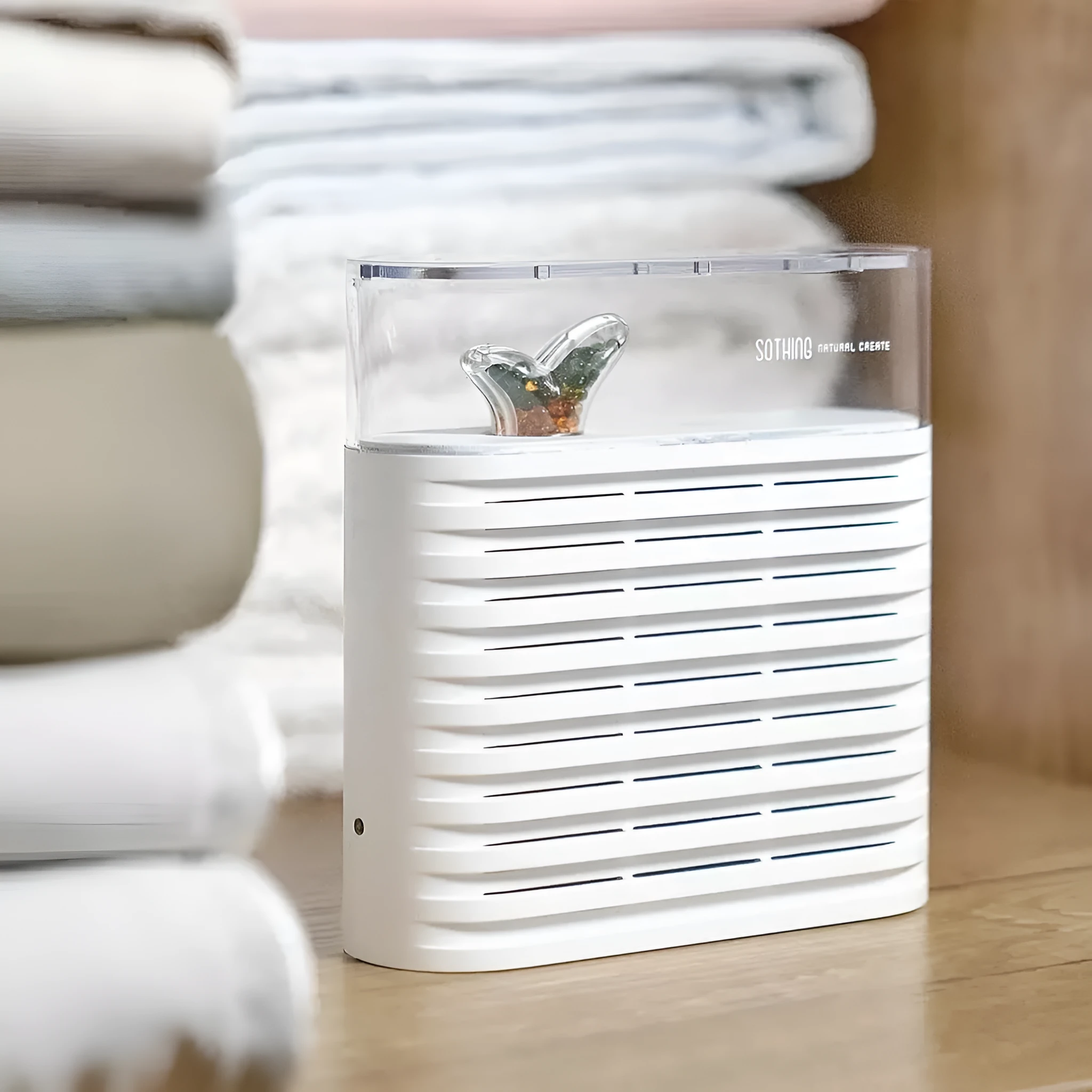 White recyclable cabinet dehumidification box with transparent geometric top cover showing colour-changing silica gel inside.