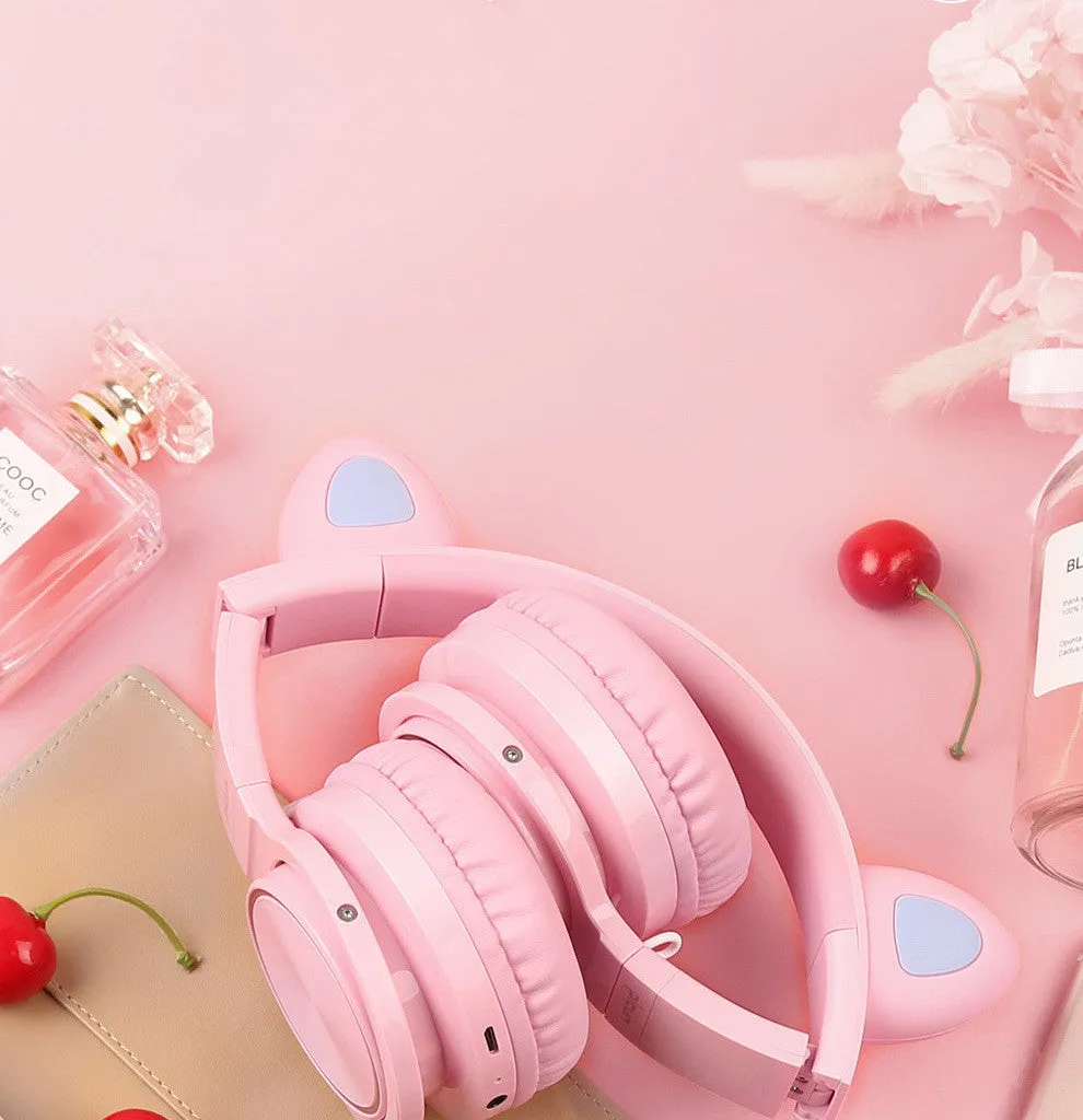 Pink and white Luminous wireless Bluetooth gaming headset with over-ear earcups and a braided cable.