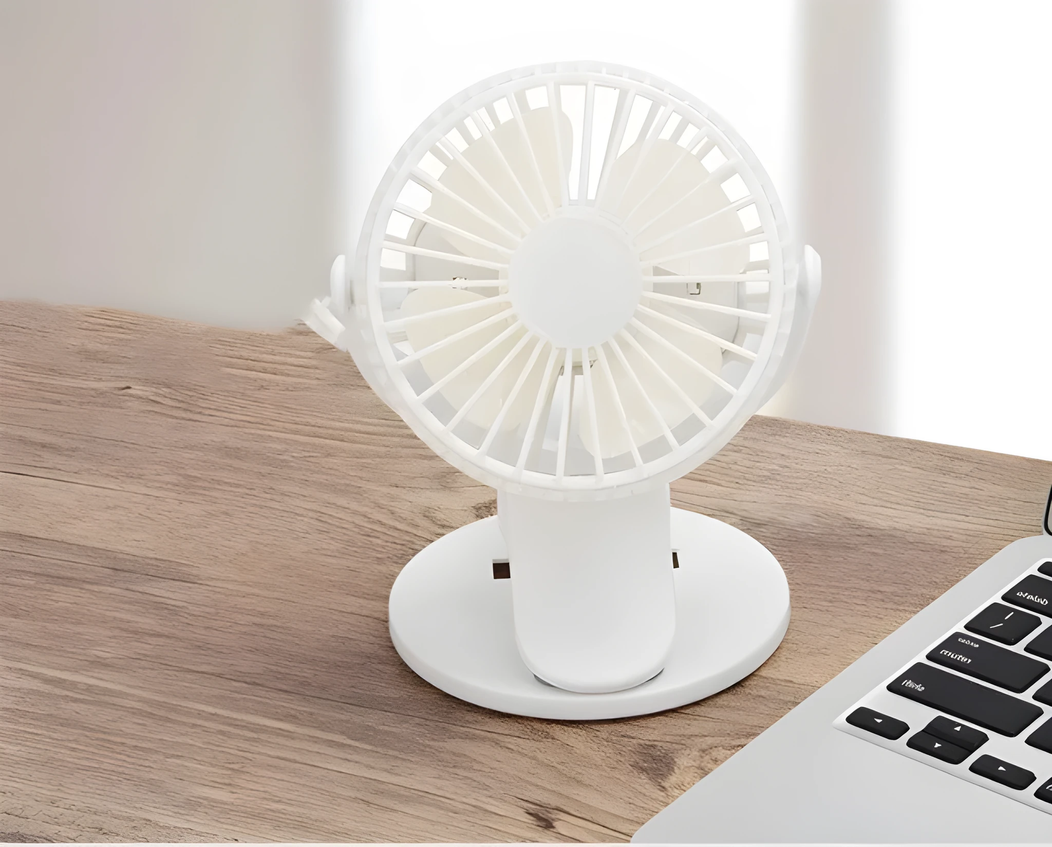 Small white USB rechargeable clip fan with plastic blades attached to desk edge