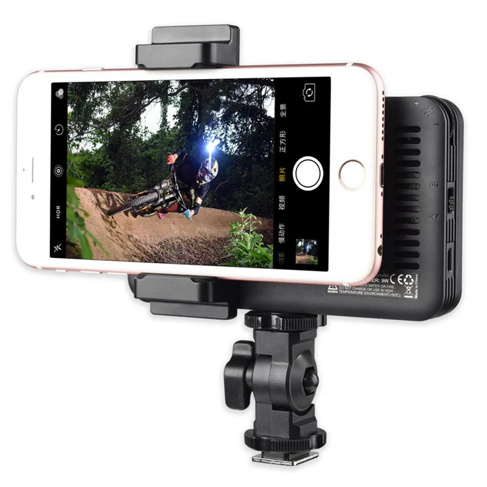 Slim silver Shenniu M150 LED video light with bracket on a mobile phone.