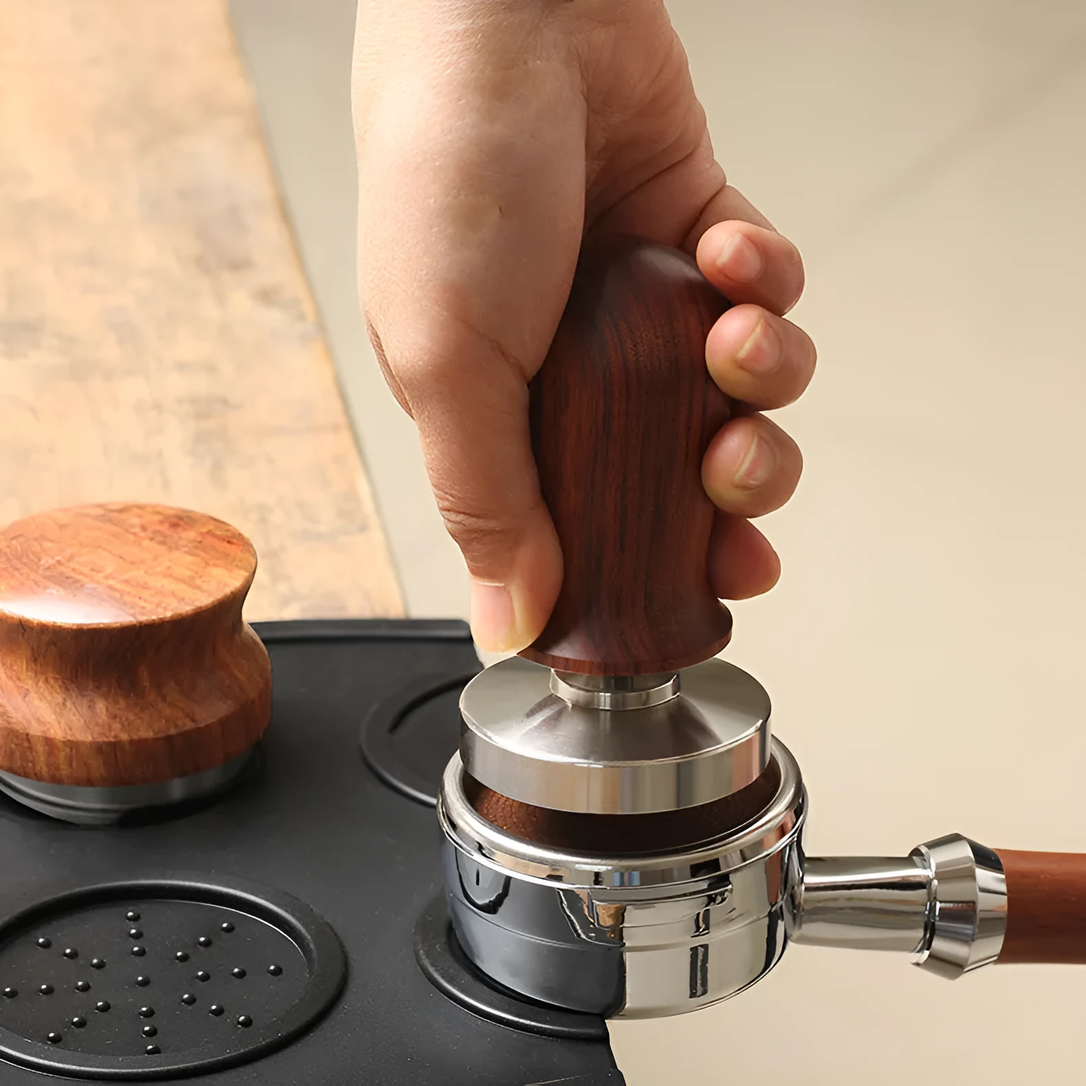 Black silicone coffee tamper pad with stainless steel base for non-slip espresso preparation