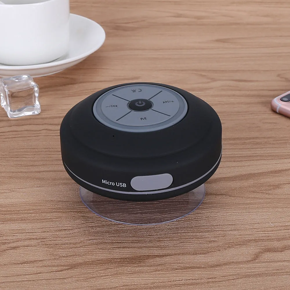 Waterproof suction cup Bluetooth speaker in black attached to a tiled wall