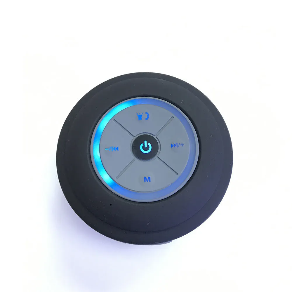 Waterproof suction cup Bluetooth speaker in black attached to a tiled wall