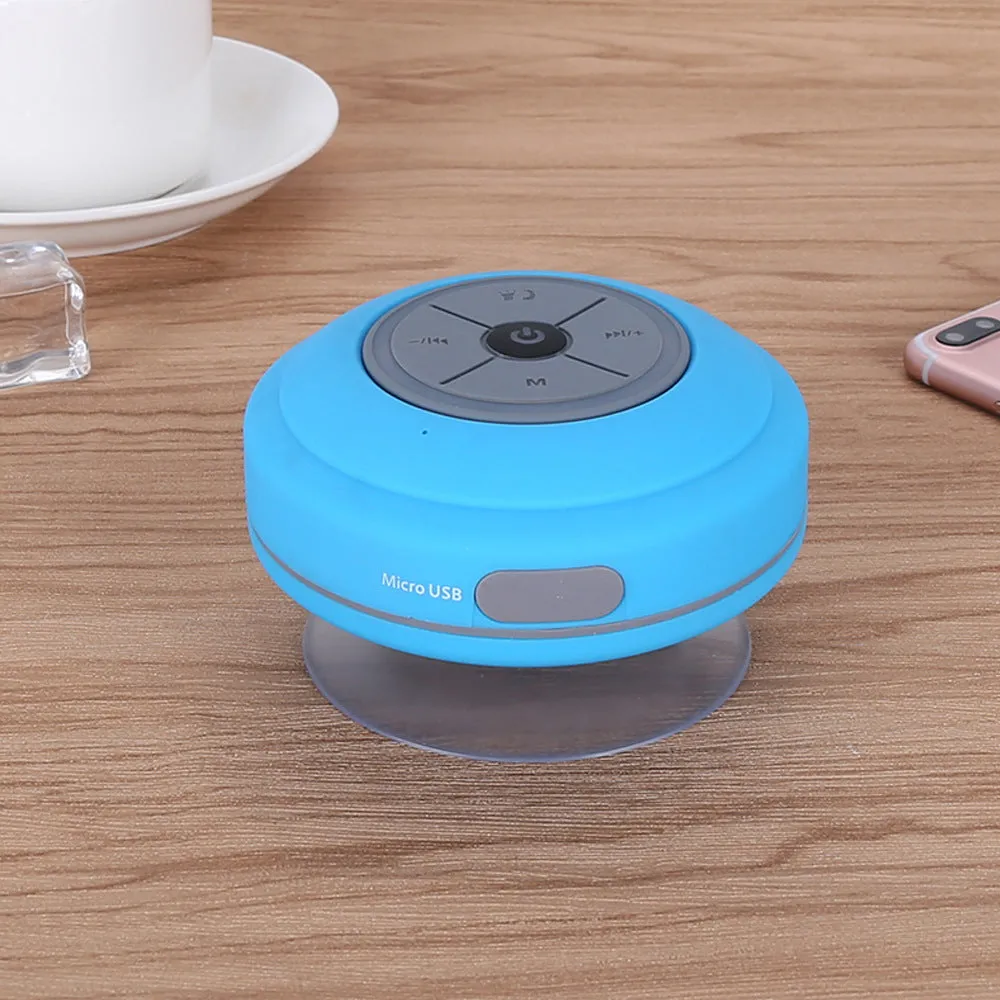Waterproof suction cup Bluetooth speaker in black attached to a tiled wall