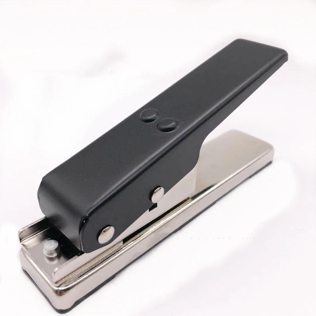 Gold metal guitar pick card cutter on a flat surface showing the punch head and metallic finish