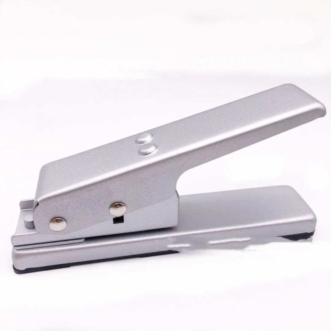 Gold metal guitar pick card cutter on a flat surface showing the punch head and metallic finish