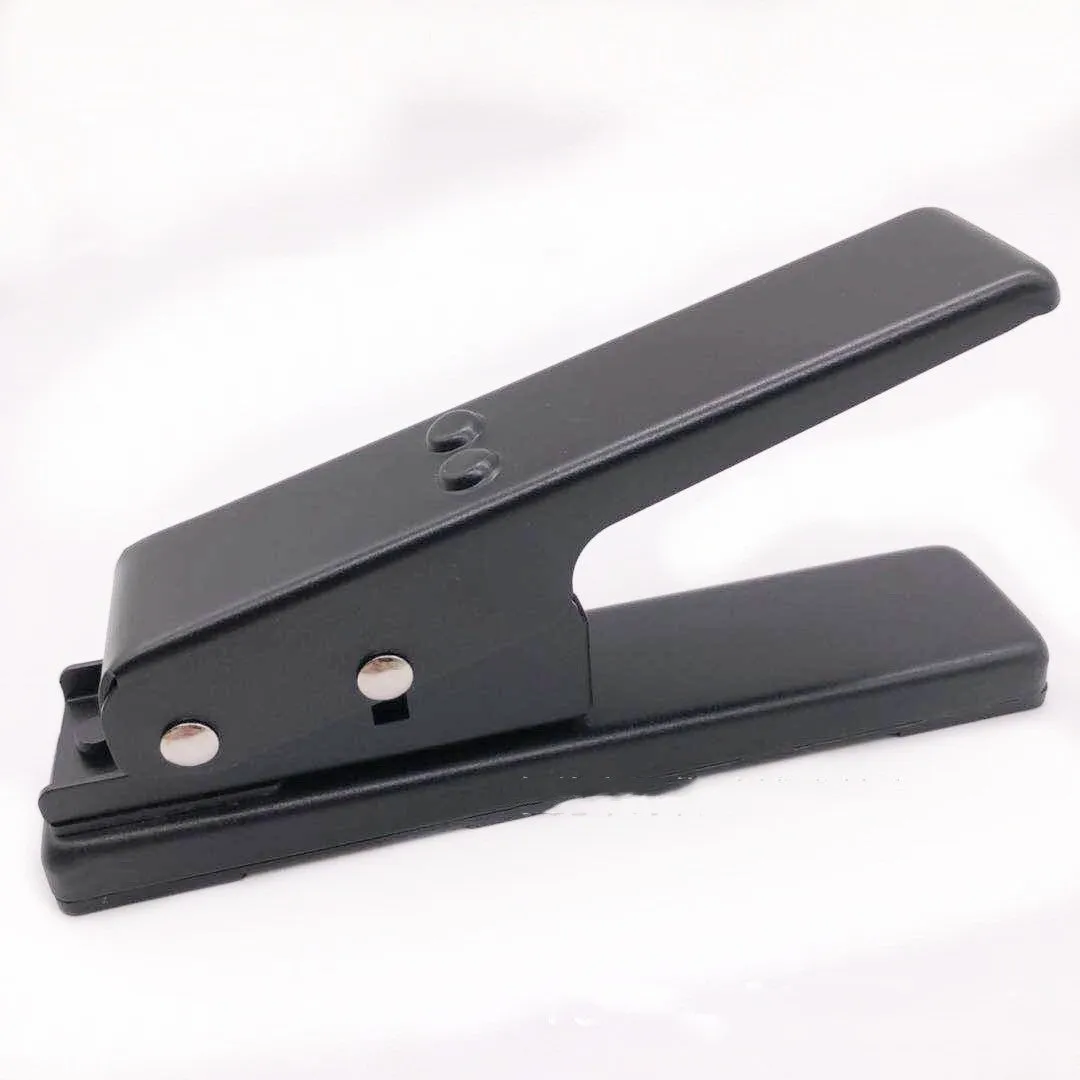 Gold metal guitar pick card cutter on a flat surface showing the punch head and metallic finish