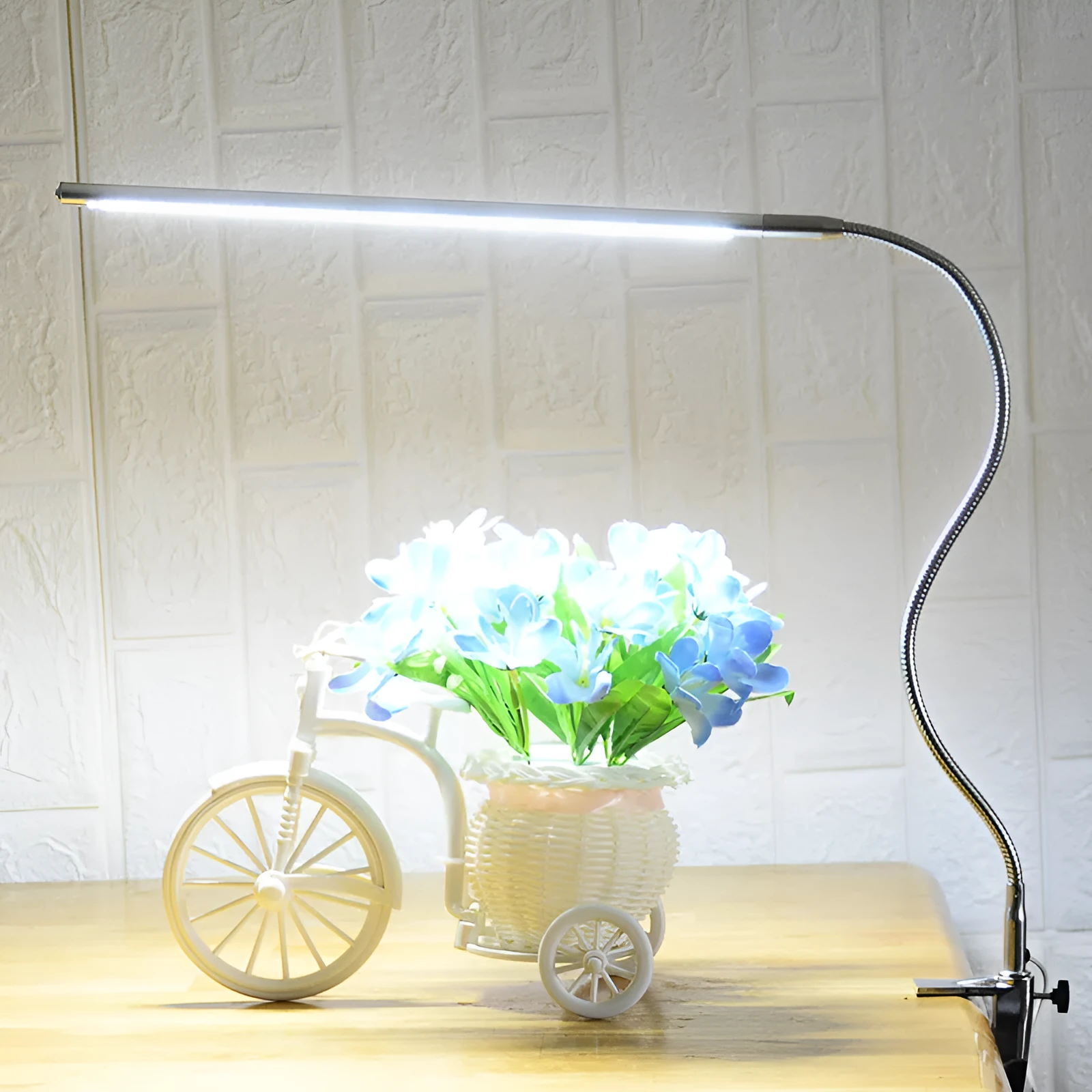 Silver aluminium alloy USB LED nail lamp with long arm and clip-on base, lit with bright white light.