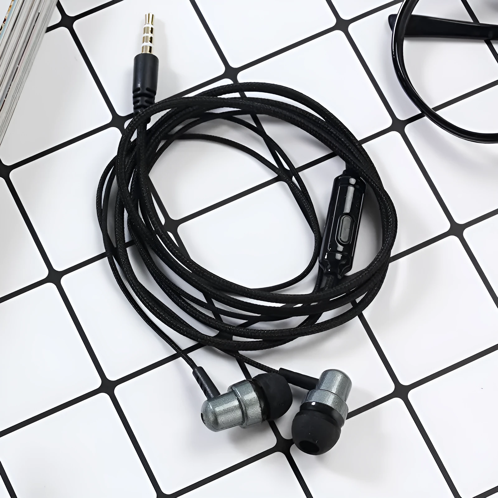 Direct-plug wired in-ear gaming headset with silicone earplugs, braided cable, and built-in microphone in black