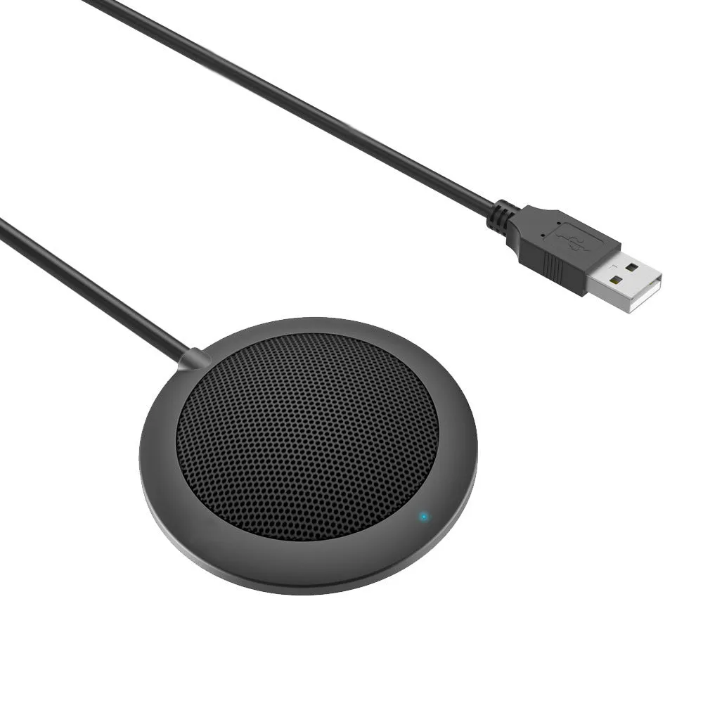 Black USB desktop microphone with metal mesh cover on a desk next to a laptop