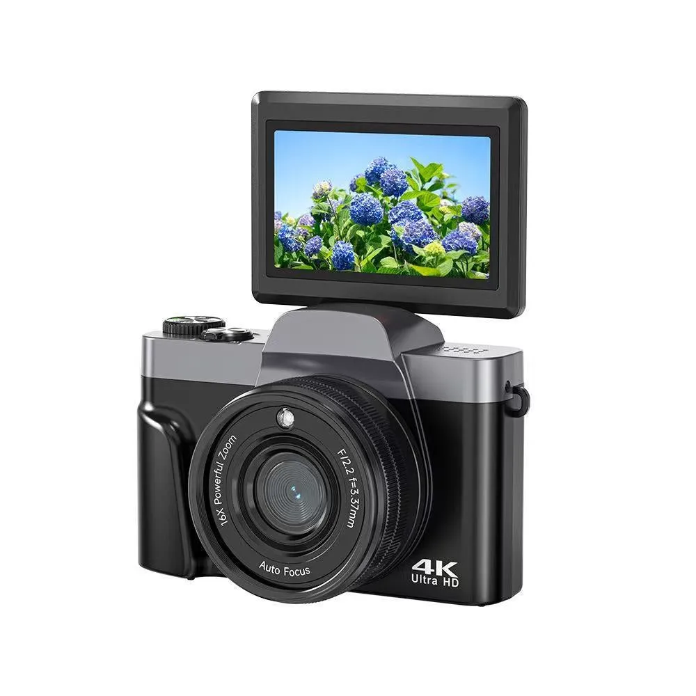 Black flip mirrorless digital camera resting on a cloth surface, showing its compact body and flip screen