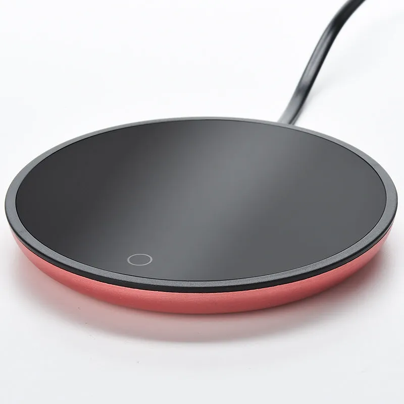 Electric constant temperature cup warmer pad in red colour on a desk with a coffee cup