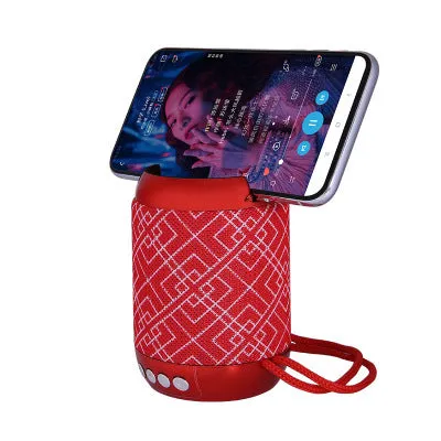 Mini wireless Bluetooth speaker with fabric covering in blue, showing button controls and compact size