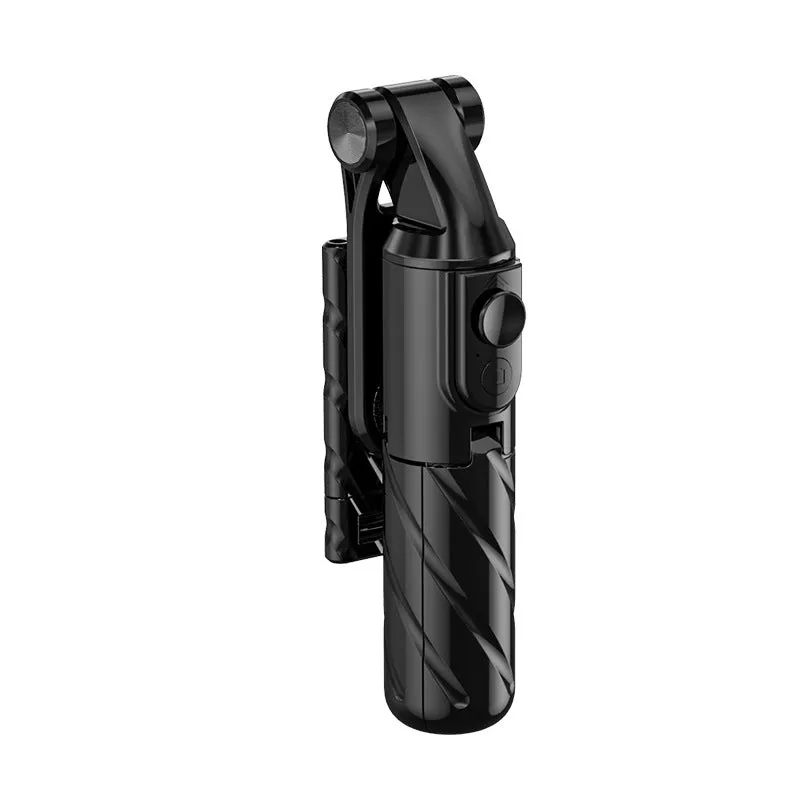 V03 black mini selfie stick Bluetooth tripod extended to 70 cm on a tabletop, phone attached and remote control visible