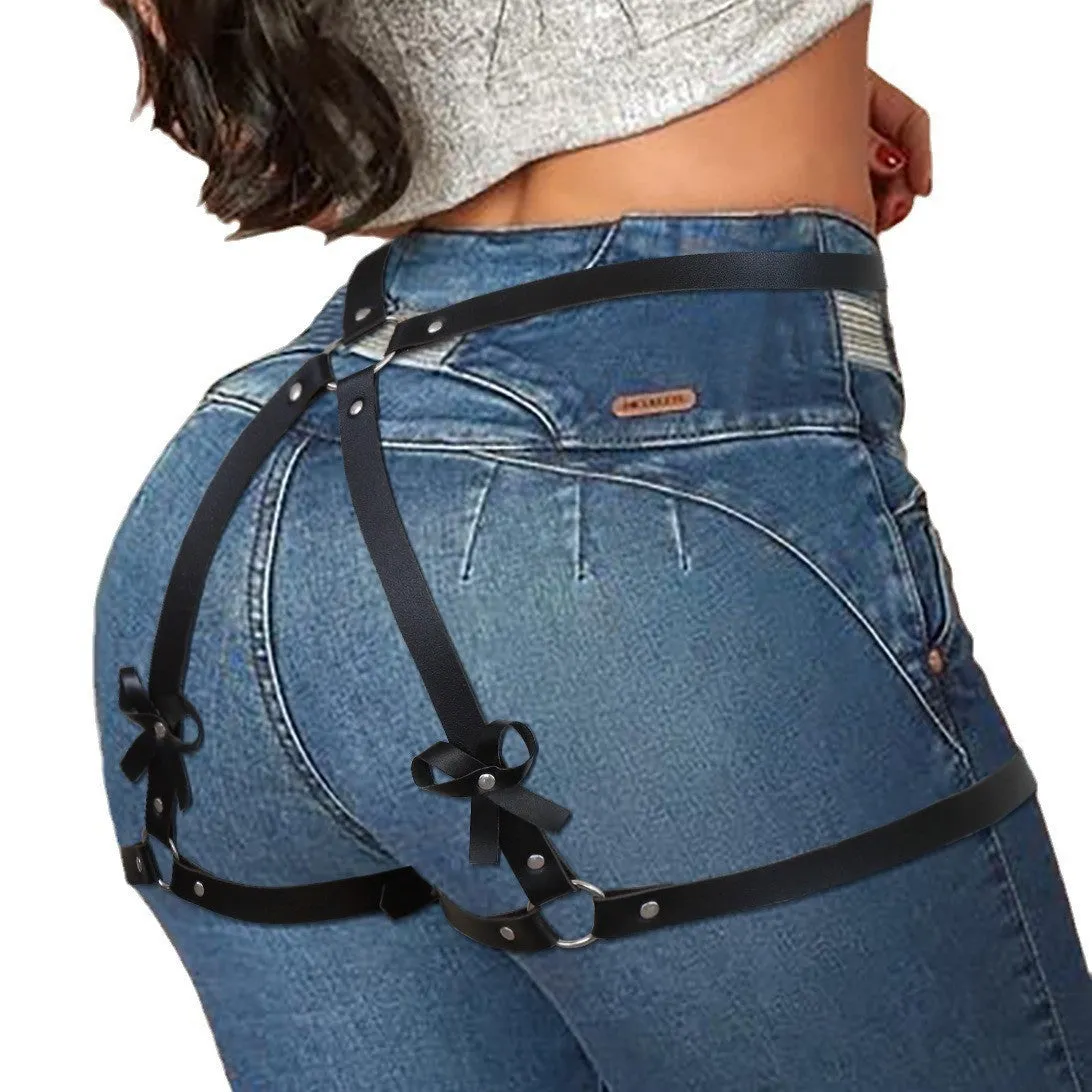 Black leather-look belt with metal buckle and bow detail, handcuffs from same set, on a dark surface