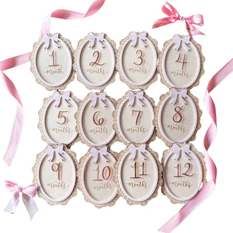 Carved boxwood lace frame bow baby milestone card with ten number stickers on a white background