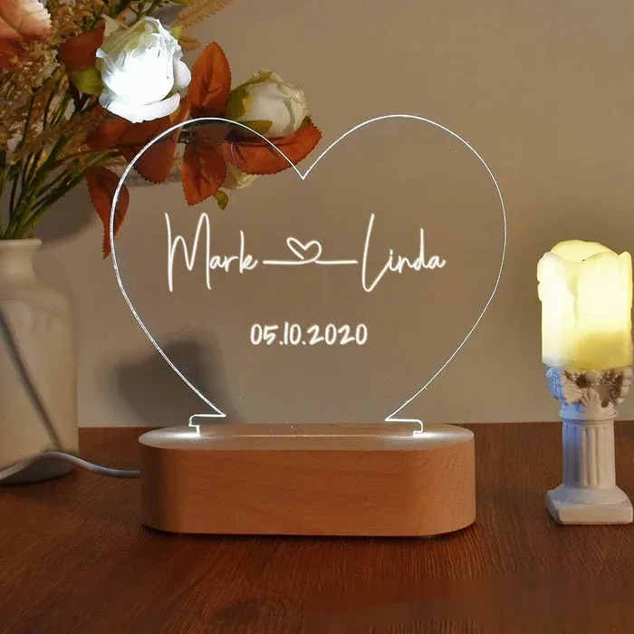 Custom acrylic night light with engraved names and date, lit by LED base.