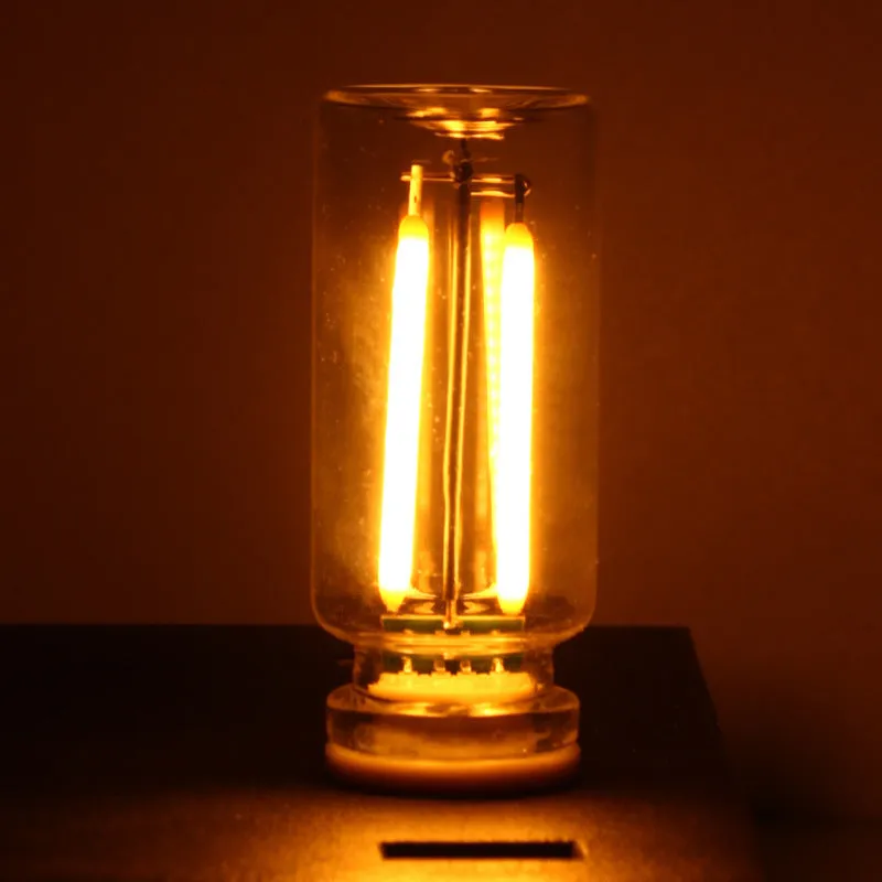 Small transparent glass USB touch night lamp with warm white light on a desk