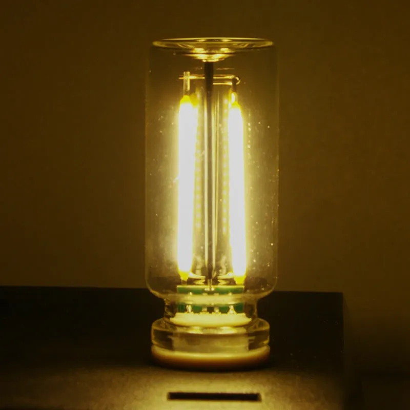 Small transparent glass USB touch night lamp with warm white light on a desk