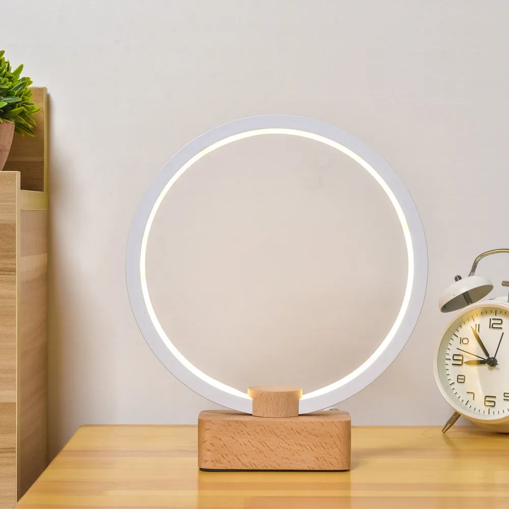 Round small solid wood and bamboo USB-powered LED night lamp on a table.