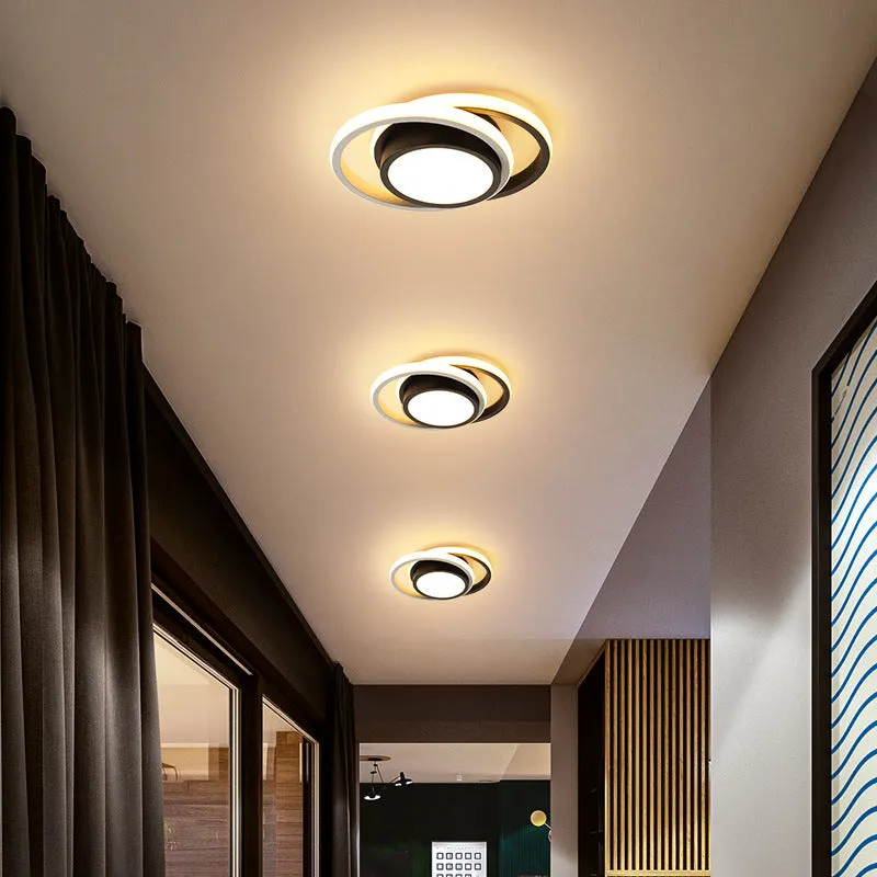 Modern round aluminium ceiling light with integrated LEDs, shown illuminating an entrance hall.