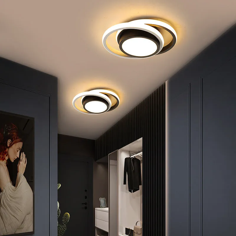 Modern round aluminium ceiling light with integrated LEDs, shown illuminating an entrance hall.