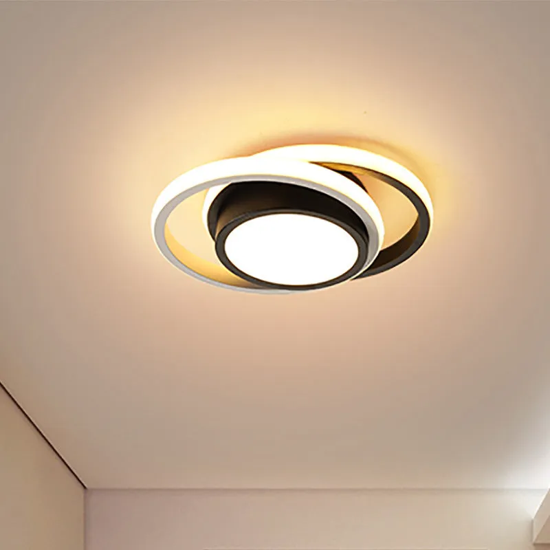 Modern round aluminium ceiling light with integrated LEDs, shown illuminating an entrance hall.