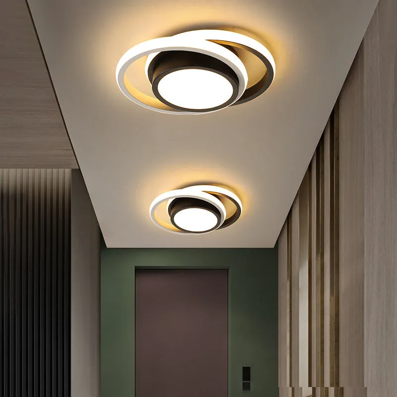 Modern round aluminium ceiling light with integrated LEDs, shown illuminating an entrance hall.