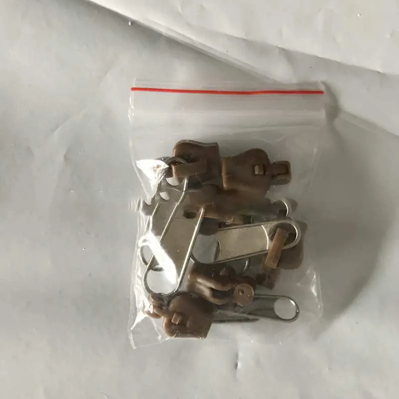 Reusable zipper head repair kit with 12 plastic and metal sliders in black, black grey, and coffee brown colours