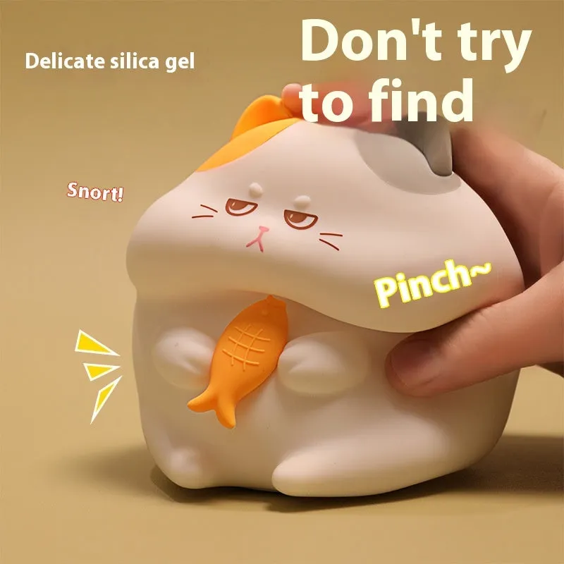 Small greedy cat cartoon desktop night light with yellow fin tuna design on a desk.