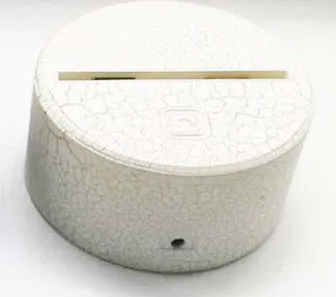 White lotus-shaped acrylic night light with LED base and touch controls on a wooden table.