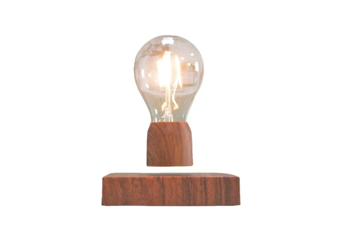 Magnetic levitation desk lamp with floating light bulb on imitation wood base.