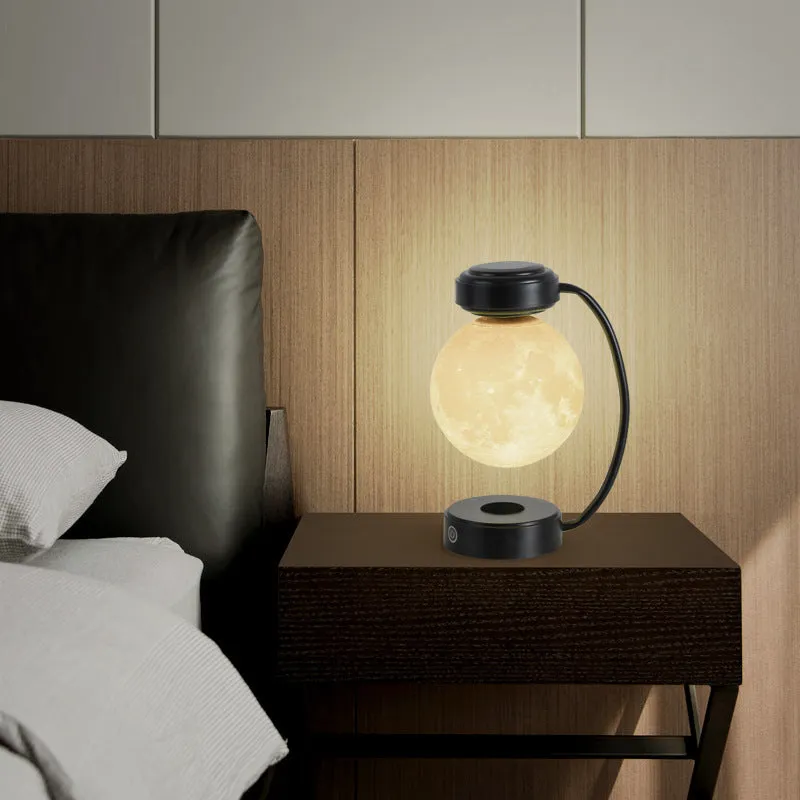 Black magnetic levitation moon lamp floating above base with touch control for bedside use