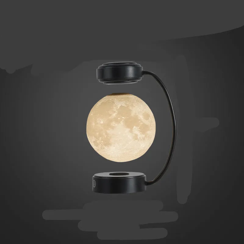 Black magnetic levitation moon lamp floating above base with touch control for bedside use