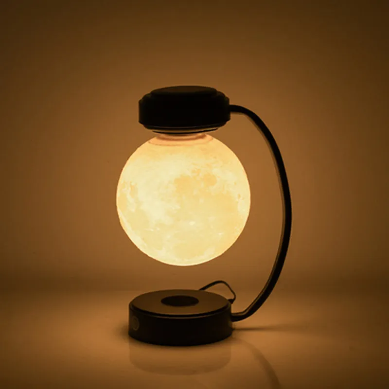 Black magnetic levitation moon lamp floating above base with touch control for bedside use