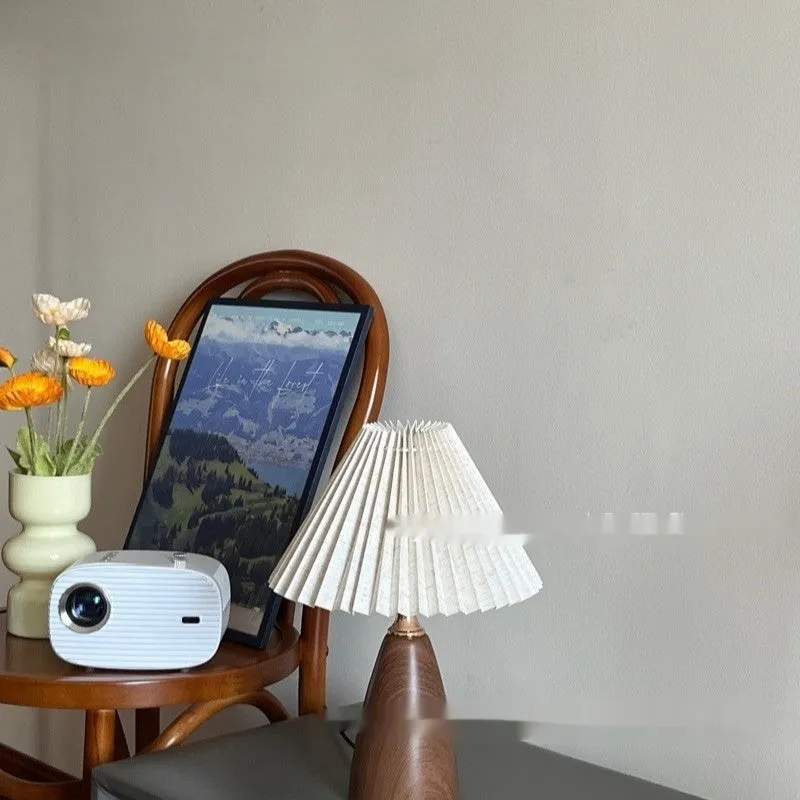 Nordic retro ceramic table lamp with pleated floral shade and remote control on a wooden bedside table.