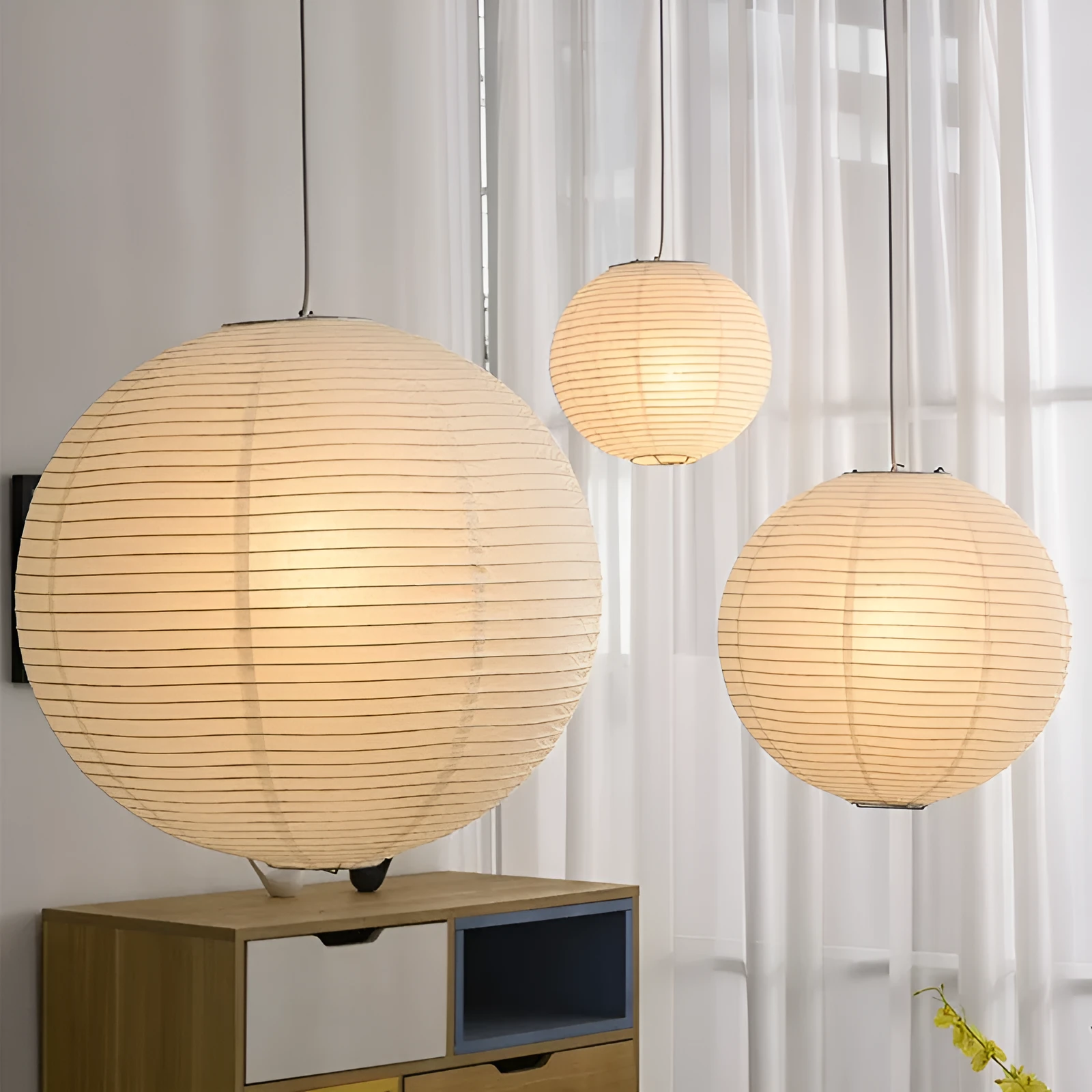 Modern paper pendant lamp with bamboo frame hanging from ceiling, shown in multiple diameter sizes.