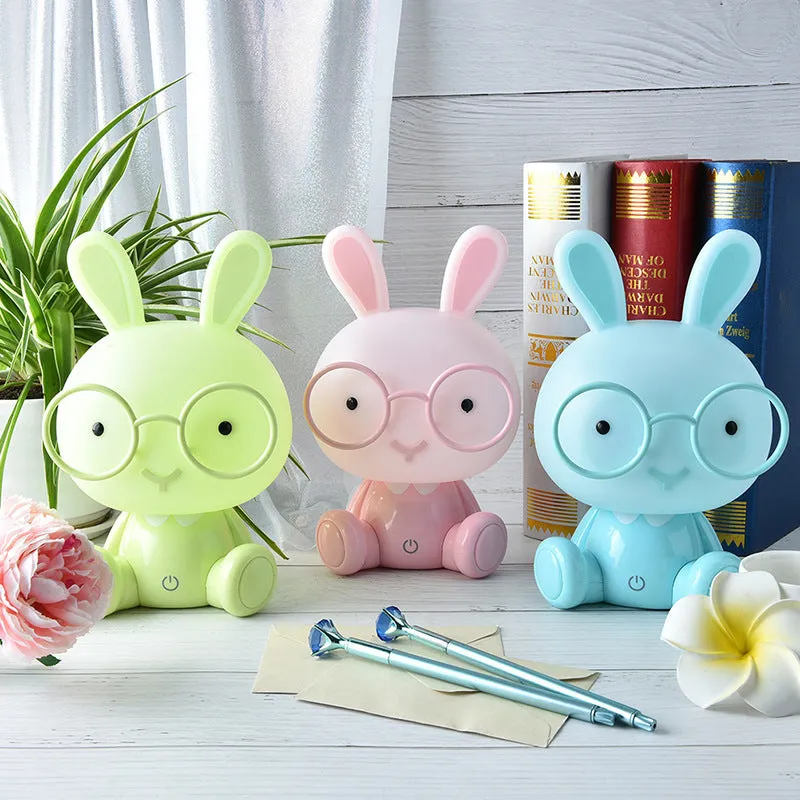 Blue cartoon rabbit-shaped USB night light with glasses on a table