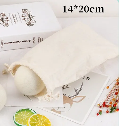 Natural wool laundry drying balls in various sizes next to plain cotton storage bag