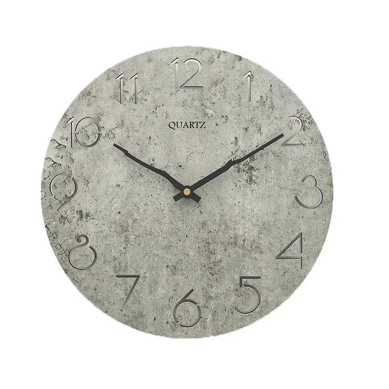 Modern grey European-style wall clock with a round face on a white wall.