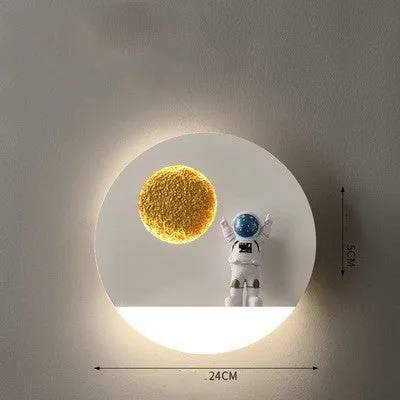 Modern black or white astronaut-shaped wall lamp with integrated shelf and LED light for bedside use.