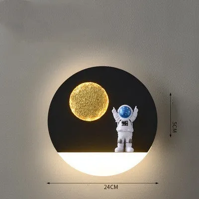 Modern black or white astronaut-shaped wall lamp with integrated shelf and LED light for bedside use.