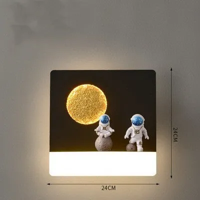 Modern black or white astronaut-shaped wall lamp with integrated shelf and LED light for bedside use.