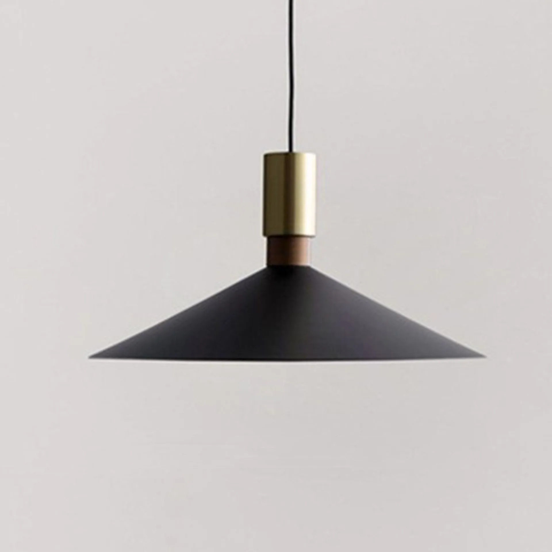 Minimalist round single-headed iron pendant lamp in black, shown in a dining setting.