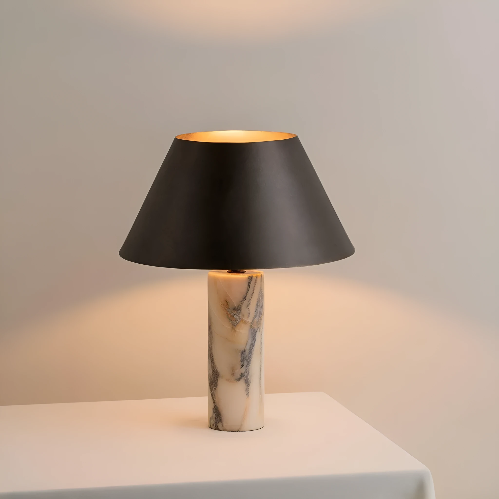 Modern black table lamp with a textured marble base on a wooden desk.